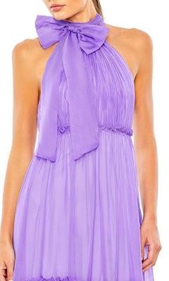 A woman wears the Mac Duggal 55848 high-neck long formal dress, a sleeveless lavender gown with pleats and a large bow at the neckline.