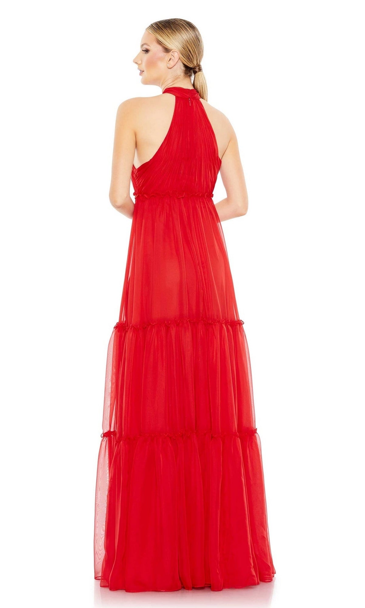 A woman faces away, wearing the Mac Duggal 55848 High-Neck Long Formal Dress in bold red, featuring a sleeveless design and tiered sheer skirt. Her hair is styled in a low ponytail.