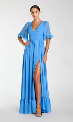 A woman models the Long Formal Dress 55867 by Mac Duggal, featuring a light blue hue, deep V-neckline, ruffled sleeves and hem, and a high slit, against a plain light background.