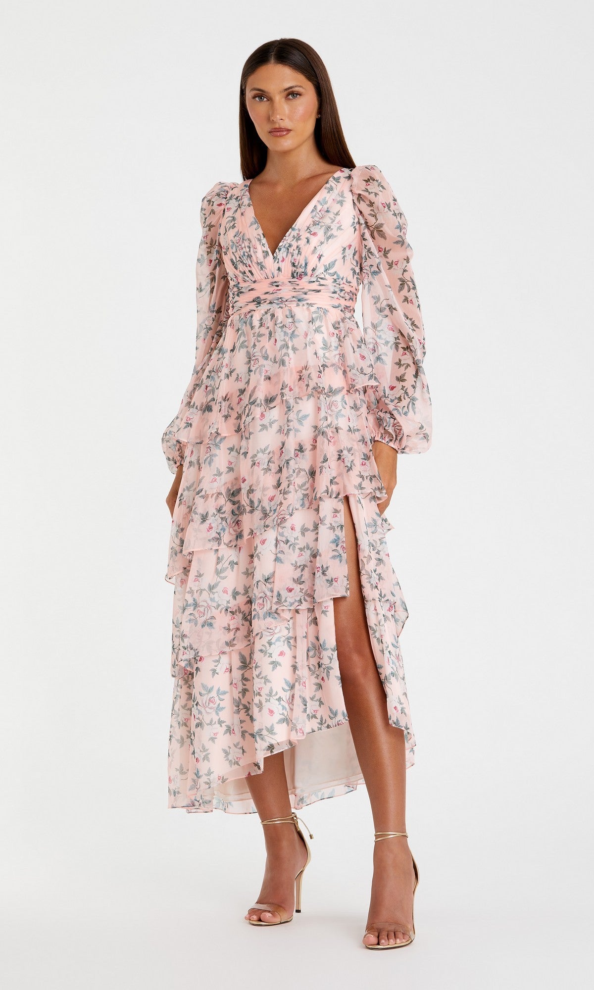A woman stands in strappy high-heeled sandals, wearing the Mac Duggal 55880 Print Midi Wedding Guest Dress with long sleeves and ruffled layers—an elegant floral option—set against a plain white background.