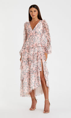 A woman stands in strappy high-heeled sandals, wearing the Mac Duggal 55880 Print Midi Wedding Guest Dress with long sleeves and ruffled layers—an elegant floral option—set against a plain white background.