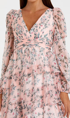 Woman in the Mac Duggal 55880 Print Midi Wedding Guest Dress—light pink with long sleeves, floral print, V-neckline, and tiered ruffle layers. An ideal choice for wedding guests.