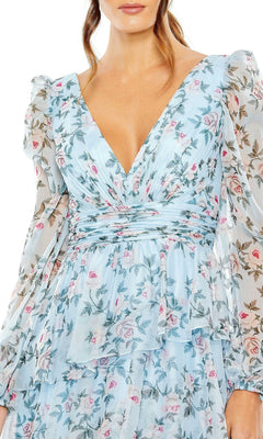 Woman in a light blue Mac Duggal 55880 midi dress featuring floral print, sheer puffed long sleeves, and a deep V neckline. Only the upper half is visible—an elegant pick for wedding guests.