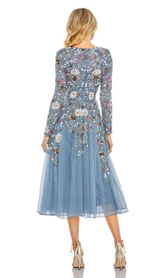 Wearing the Mac Duggal 5594 midi wedding guest dress with blue long sleeves and floral beading, she stands with her back to the camera, paired with metallic heels—a chic choice for any wedding event.