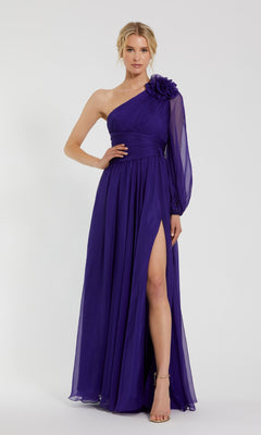 A woman wears the Mac Duggal 56073 one-shoulder purple formal dress featuring a floral detail and high slit, styled with strappy heels.