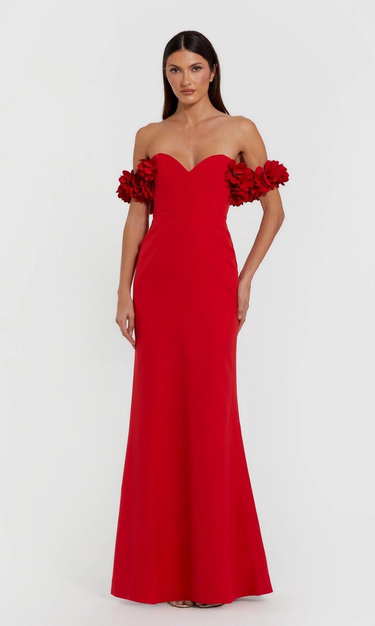 A woman wears the Mac Duggal 56131 Floral-Straps Long Formal Dress—a floor-length red gown featuring 3D floral straps—standing against a plain white background.