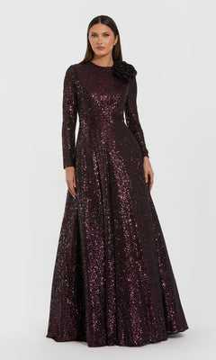 A woman poses against a white background in the Mac Duggal 56178 Amethyst Sequin Formal Dress, featuring a floor-length silhouette, long sleeves, and a floral-embellished shoulder—an elegant mother of the bride choice.