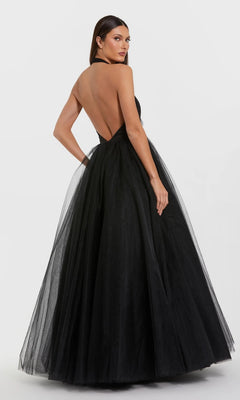 A woman poses with her back to the camera against a plain white background, wearing the Long Formal Dress: Mac Duggal 56187, a black, floor-length, backless halter gown.