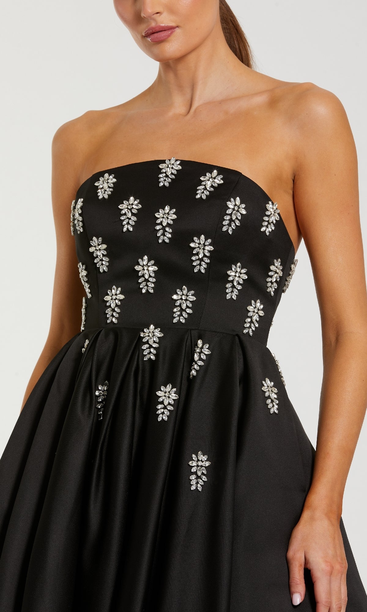 Black strapless dress with crystal floral embellishments on a plain background