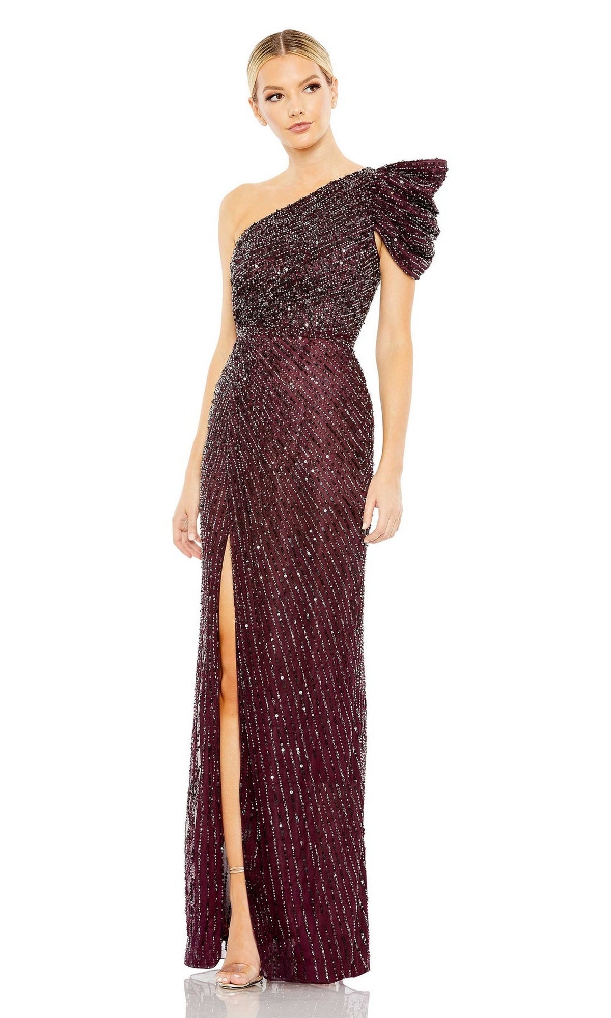 A woman wears the Long Formal Dress 5622 by Mac Duggal—an elegant burgundy one-shoulder evening gown with sequins, a thigh-high slit, fitted floor-length silhouette, and an eye-catching ruffled sleeve.