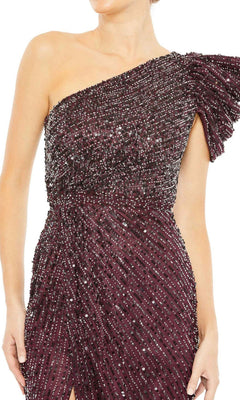 Someone wearing the Long Formal Dress 5622 by Mac Duggal, a one-shoulder, dark burgundy gown with sequin and bead embellishments, ruched detailing, and an asymmetrical sleeve.