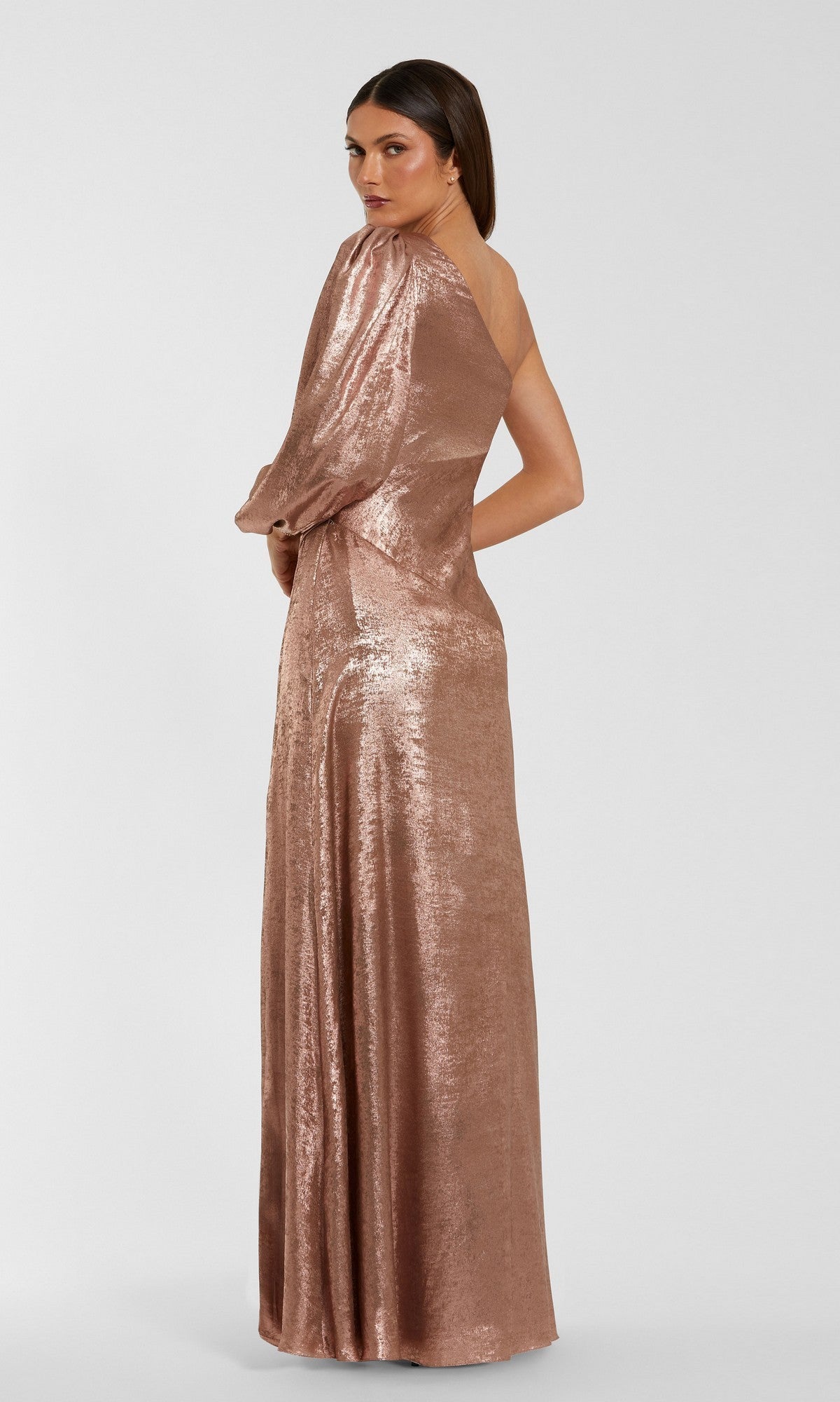 A woman stands slightly turned away against a simple light background, wearing the Mac Duggal 56226—an elegant, floor-length, one-shoulder long formal dress that shines with metallic pink sequins for a strikingly glamorous appearance.