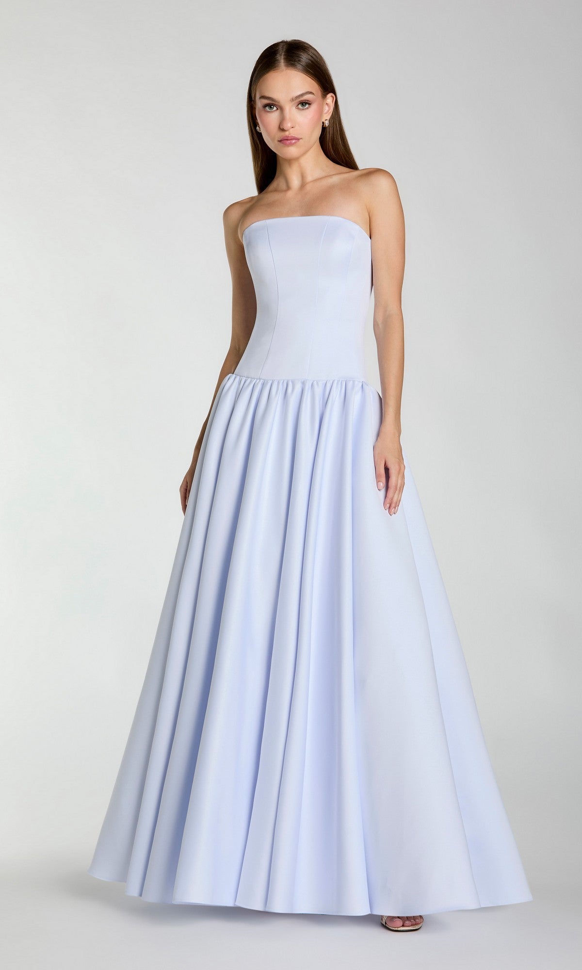 A woman wearing the Mac Duggal 56270 long formal dress—a floor-length, powder blue gown with a fitted bodice and a flared A-line skirt—stands against a plain background.