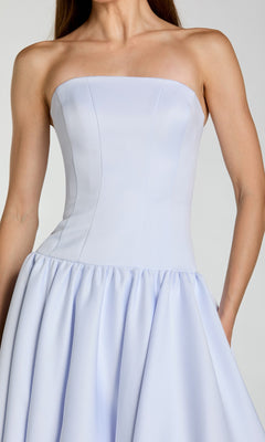 A woman is shown from shoulders to mid-thigh, standing against a plain background, wearing the Mac Duggal 56270 Long Formal Dress in light blue. The dress features a strapless design with a fitted bodice and a flared skirt reminiscent of an A-line evening gown.