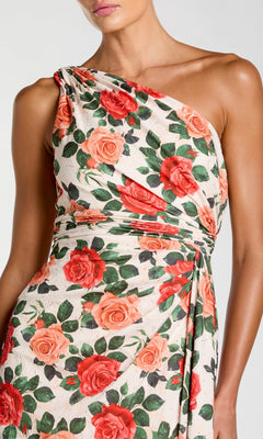 A woman wearing the Mac Duggal 56297 long formal dress, featuring a one-shoulder design and a red and orange rose print on a white background.