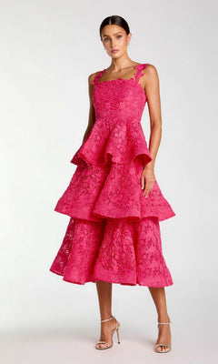 A woman wearing the Mac Duggal 56322 Midi Party Dress in hot pink—a sleeveless party dress featuring tiered lace embroidery and a square neckline—stands against a plain light background in strappy high-heeled sandals for a chic look.