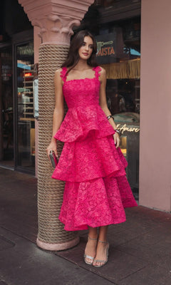 Outdoors, a woman wears the Mac Duggal 56322 Midi Party Dress—a hot pink, sleeveless, tiered lace-embroidered party dress—styled with strappy heels and a chic clutch.