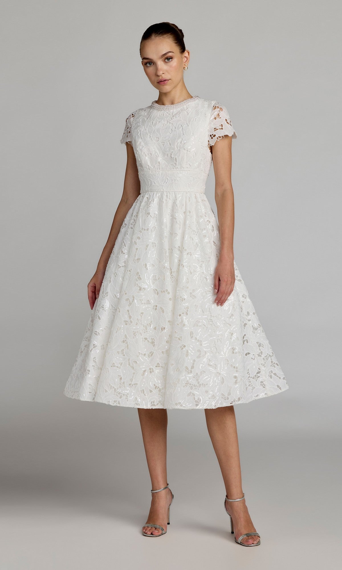 A woman wearing the Mac Duggal 56324 Midi Party Dress in ivory, featuring a fit-and-flare midi silhouette with short sleeves, styled with silver high-heeled sandals and standing against a plain background.
