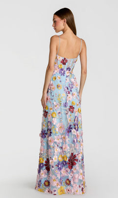 A woman is shown from the back against a plain white background wearing the Long Formal Dress: Mac Duggal 56331, a light blue floor-length gown with colorful floral embroidery.