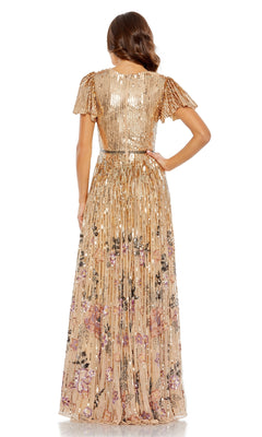 A woman stands with her back to the camera against a white background, wearing the Long Formal Dress 5637 by Mac Duggal—a gold sequin dress with floral patterns and a v-neckline.