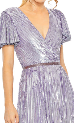 Wearing the Long Formal Dress 5637 by Mac Duggal, featuring shiny lavender sequins, short pleated sleeves, a V-neckline, and a fitted waistband.