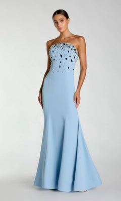 A woman wearing the Mac Duggal 56393 long formal dress in powder blue—a strapless, floor-length crepe mermaid gown with a fitted bodice and eye-catching reflective embellishments on the top.