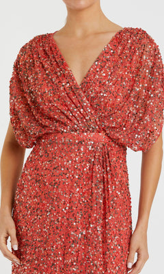 Woman wears a Mac Duggal 5640 Short Sleeve Long Sequin Formal Dress in red, featuring puffed sleeves and a deep V-neckline, shown from shoulders to hips.