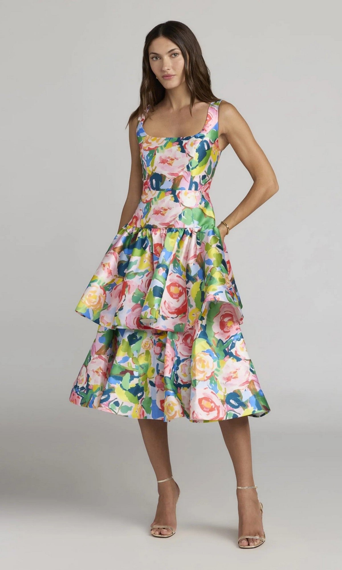 A woman is wearing the Midi Party Dress: Mac Duggal 56414 in Blue Multi, a printed mikado midi dress with a square neckline and a ruffle A-line skirt featuring a colorful floral pattern, paired with neutral heels against a plain background.