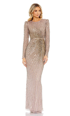 A woman models the Mac Duggal 5641 Long-Sleeve Sequin Formal Dress—a fitted, light pink gown with gold sequin stripes and a cinched waist—against a plain white background.