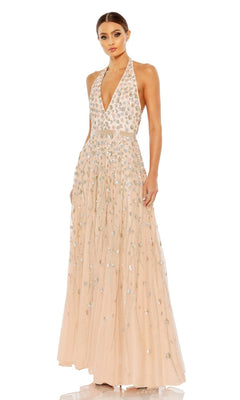 A woman wears the Long Formal Dress 5654 by Mac Duggal, a floor-length blush halter dress with a deep V-neck, sparkling sequins, and delicate floral beading for an elegant look.