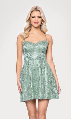 A woman models the Mini Green Sequin Hoco Dress: Blondie Nites 5705BN, a sage green spaghetti strap dress ideal for any event, shown against a plain white background and available in junior sizes.