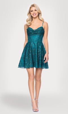 A woman smiles in the Cowl-Neck Short Hoco Dress: Blondie Nites 5713BN, featuring a teal lace design with spaghetti straps and silver heels, set against a plain light background.