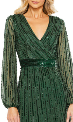 A woman wearing the Long Formal Dress 5718 by Mac Duggal—a dark green, floor-length gown with a V-neckline, sheer long sleeves, and beaded vertical stripes.