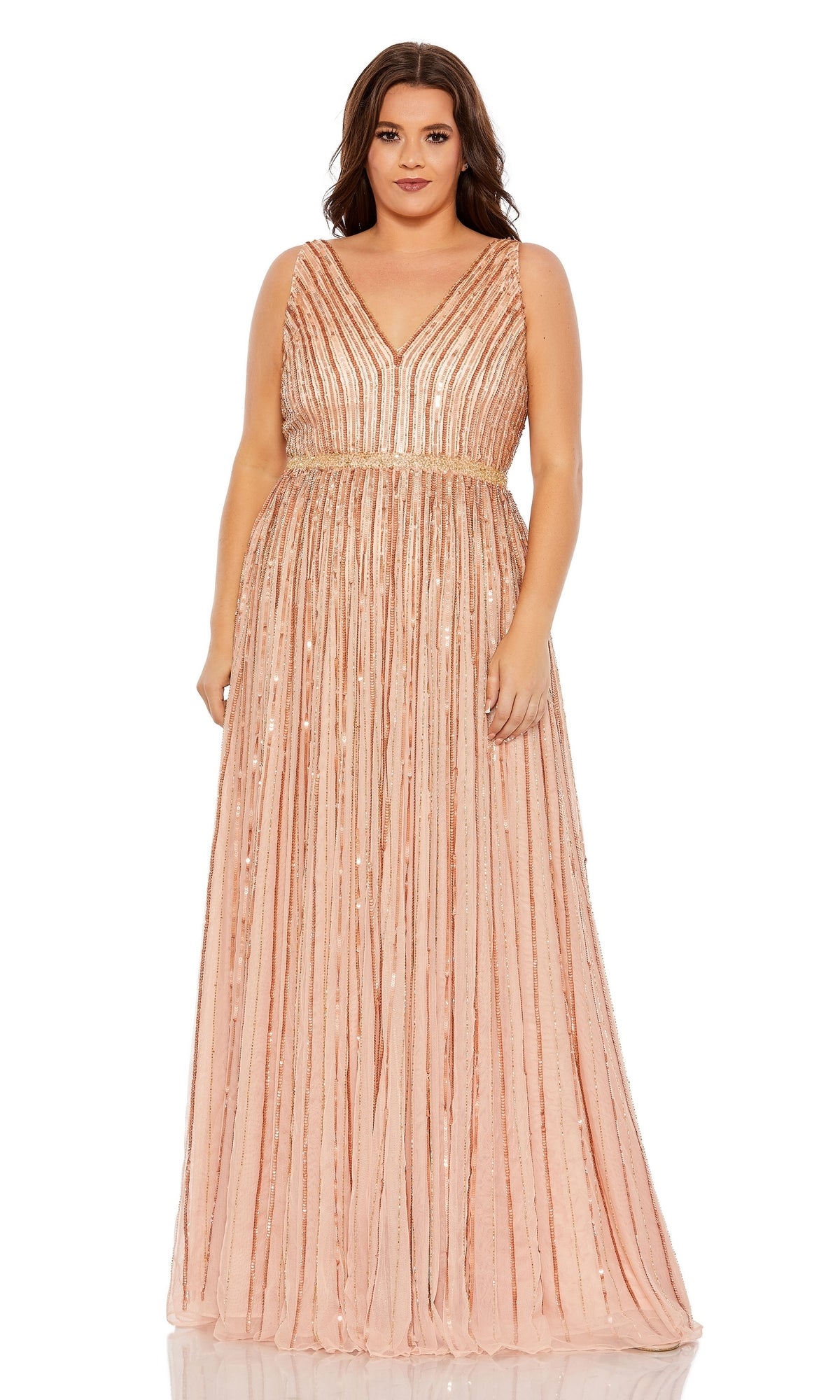 A woman stands facing forward in the Mac Duggal 5755 Plus-Size Long Sequin Formal Gown, featuring a floor-length, sleeveless blush pink design with vertical sequin stripes and a V-neckline.