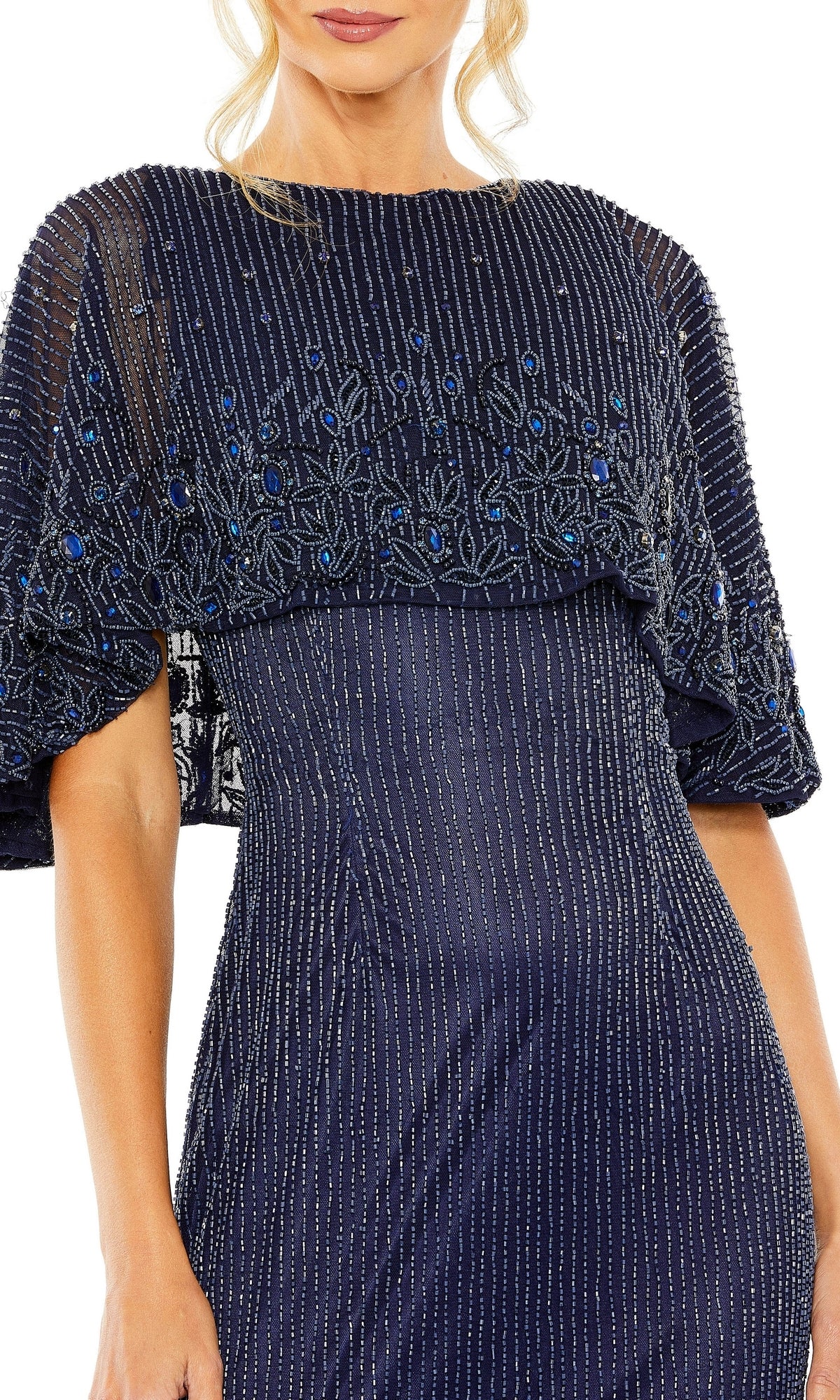 A woman wears the Midnight Blue Beaded Formal Gown by Mac Duggal 5797, featuring vertical silver stripes and a sheer capelet with blue and silver bead embellishments—a sophisticated choice for the mother of the bride.