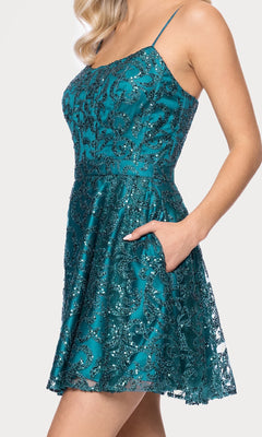 A woman wearing the Mini Teal Glitter Hoco Dress: Blondie Nites 5802BN, a short sequin dress with thin straps, fitted bodice, flared skirt, and side pockets—ideal for junior homecoming or as a sparkling party outfit.
