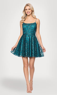 A woman models the Mini Teal Glitter Hoco Dress: Blondie Nites 5802BN, featuring sequin detailing and spaghetti straps, against a plain light background.