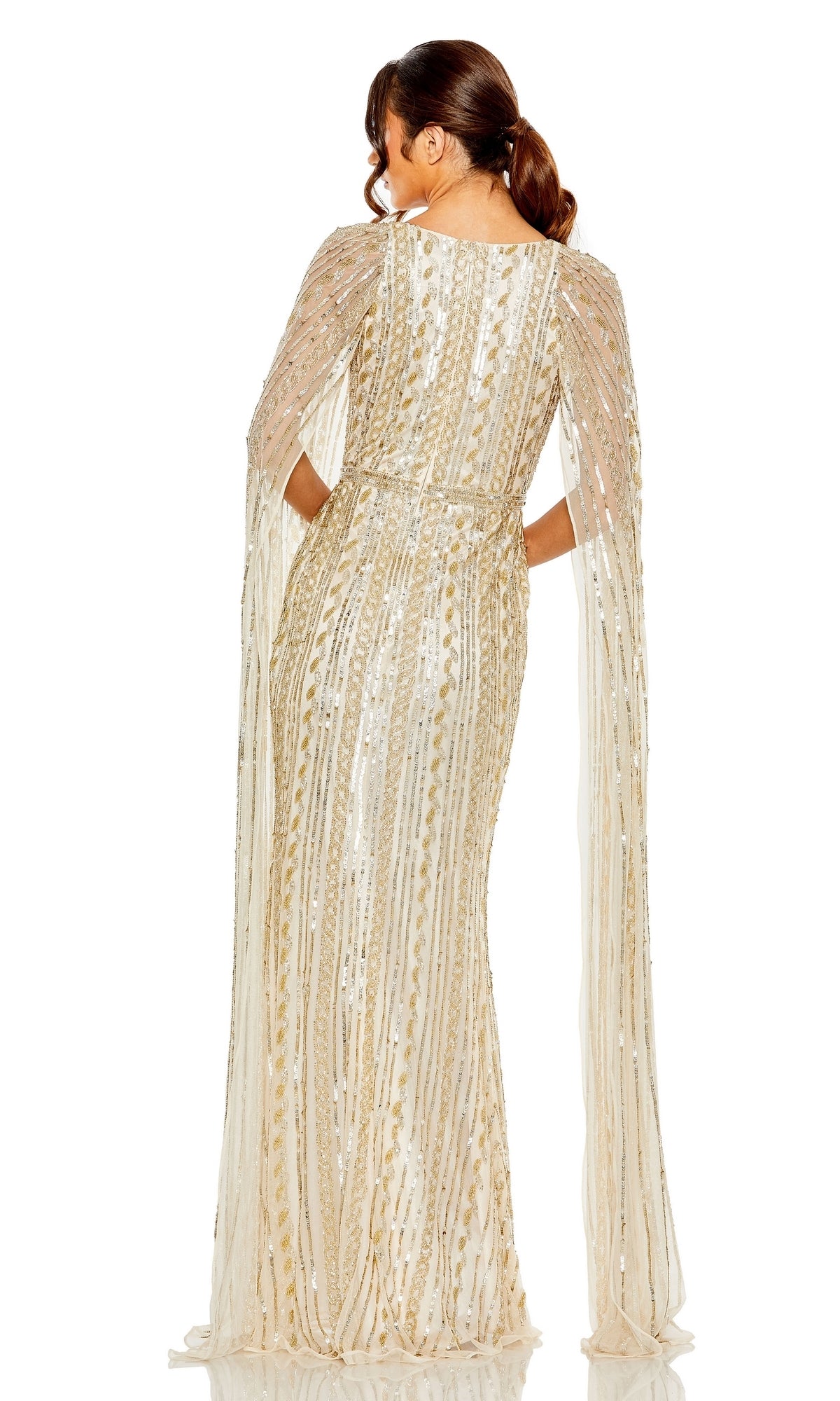 A woman models the Long Formal Dress 5915 by Mac Duggal, featuring gold and white sequins, a floor-length cape, sheer embellished sleeves, and an elegant v-neckline and back, standing against a white background.