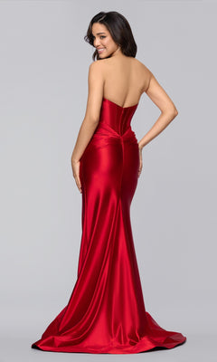 A woman models the Blondie Nites 5946BN, a strapless red satin long prom dress with a corset bodice, fitted skirt, and flowing train, posing with her back turned and glancing over her shoulder.