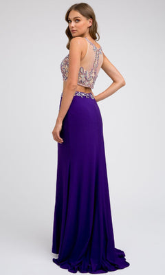 A woman stands facing backward in the Juliet 595 Long Prom Dress, featuring a purple skirt with a side leg slit and a sleeveless, beaded embellished top, set against a plain light background.