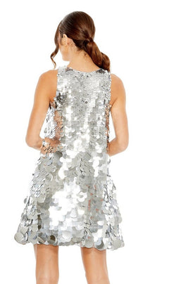 A woman with brown hair in a low ponytail is photographed from the back in a sleeveless, silver sequin Short Homecoming Dress 5961 by Mac Duggal, set against a white background.