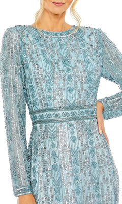 A woman in the Long Formal Dress 5981 by Mac Duggal, featuring light blue long sleeves with silver sequin patterns and beaded details, stands confidently with one hand on her hip.