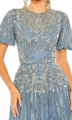 A woman wearing the Mac Duggal 5991 Short Sleeve Beaded Formal Dress in light blue, featuring intricate silver floral embroidery and bead detailing on the bodice, sleeves, and skirt.