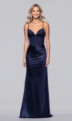 A woman wears the Blondie Nites 6014BN long navy prom dress with spaghetti straps and a fitted corset bodice, standing against a plain light gray background.