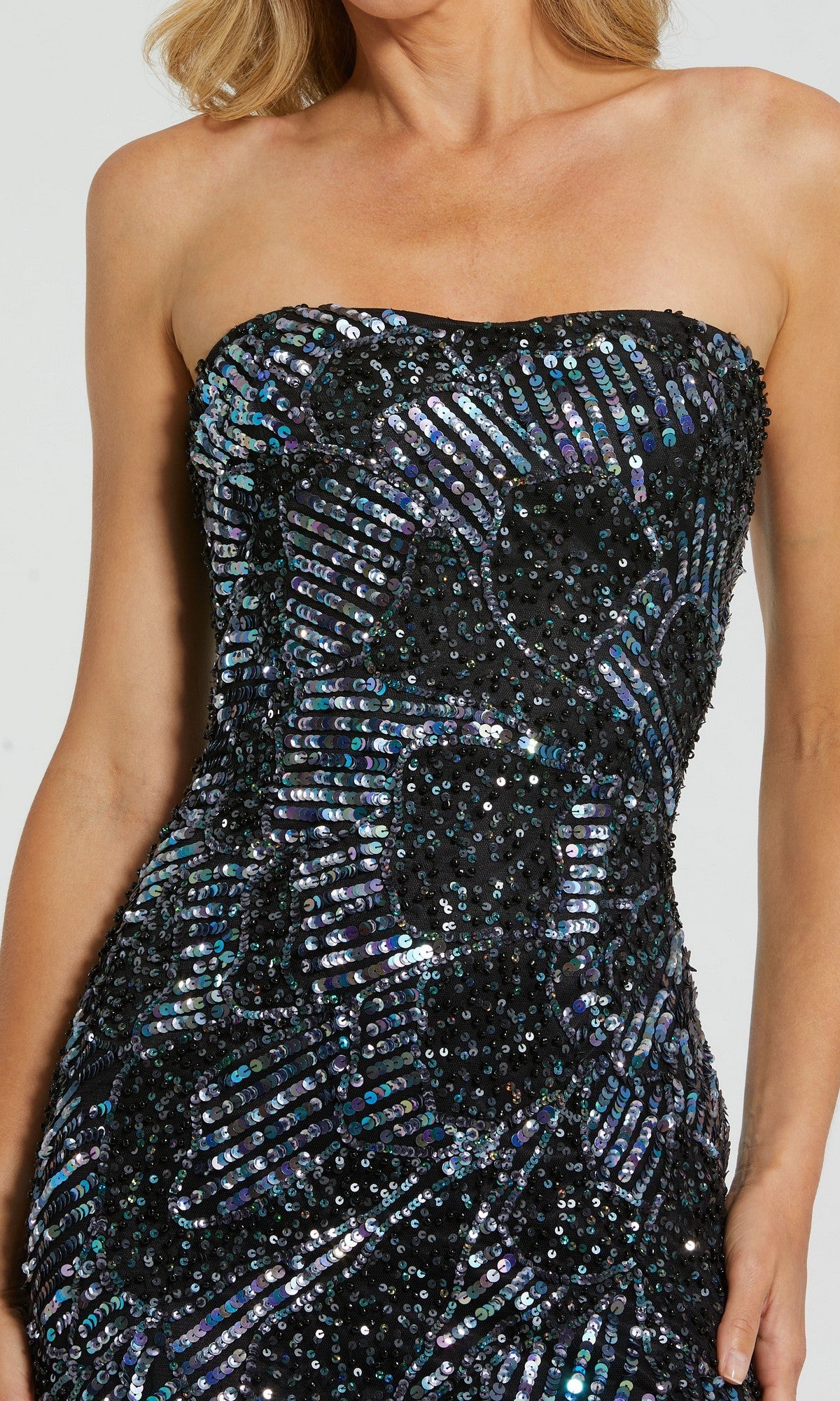 A woman wearing the Mac Duggal 6046 long formal dress, a strapless black gown fitted from the shoulders to hips and adorned with shiny, iridescent sequins.