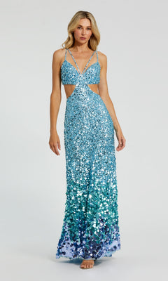 A woman models the Long Formal Dress 6077 by Mac Duggal—blue-green sequins, cut-out sides, and thin straps—while standing against a plain light gray background.