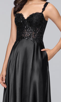 A woman wears the Blondie Nites 6088BN long black prom dress with a sleeveless sequin-embellished bodice and satin A-line skirt, standing with one hand in her pocket.