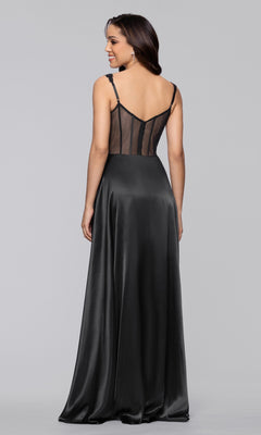A woman, smiling and facing away from the camera, wears the Blondie Nites 6088BN—a long black satin a-line prom dress with thin straps and a sheer mesh back panel.