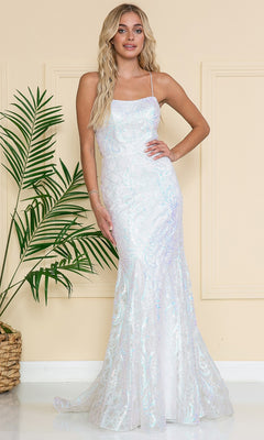 A woman in the Iridescent Long Embellished Prom Dress 6116, a fitted sleeveless white gown with iridescent details, stands indoors by a potted plant against a beige wall.