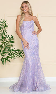 A woman stands indoors wearing the Iridescent Long Embellished Prom Dress 6116, a fitted lavender gown with thin straps and subtle glitter details. A green plant is visible to her left.